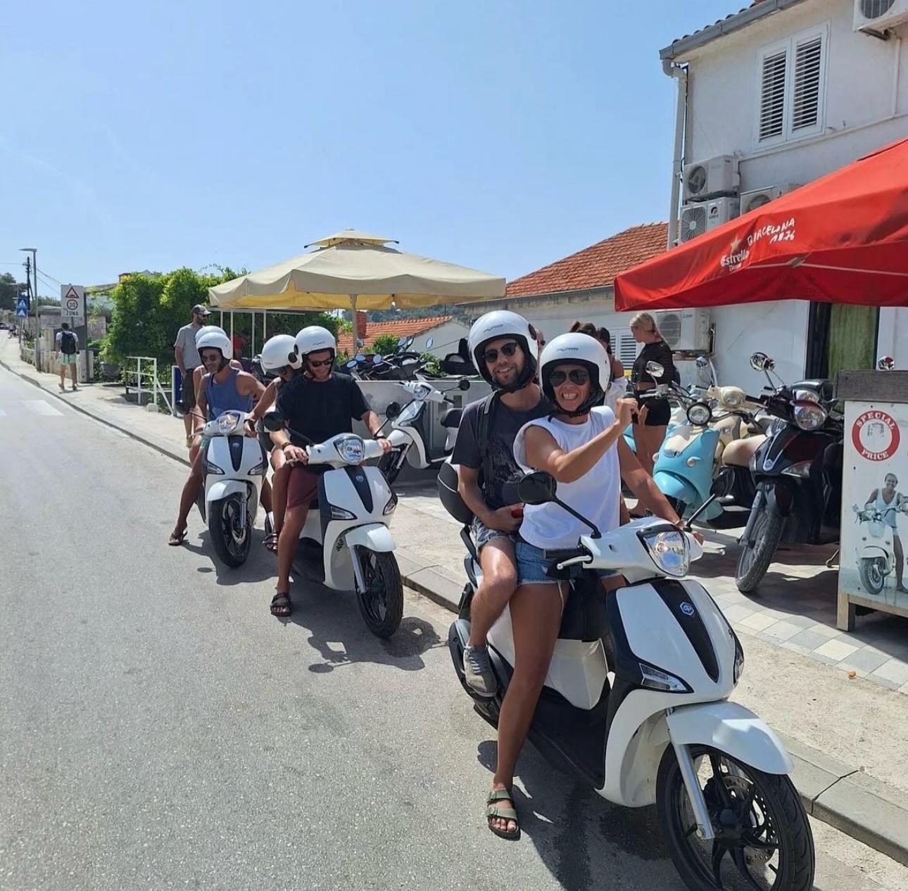 A group of guests setting off from the hostel on white scooters