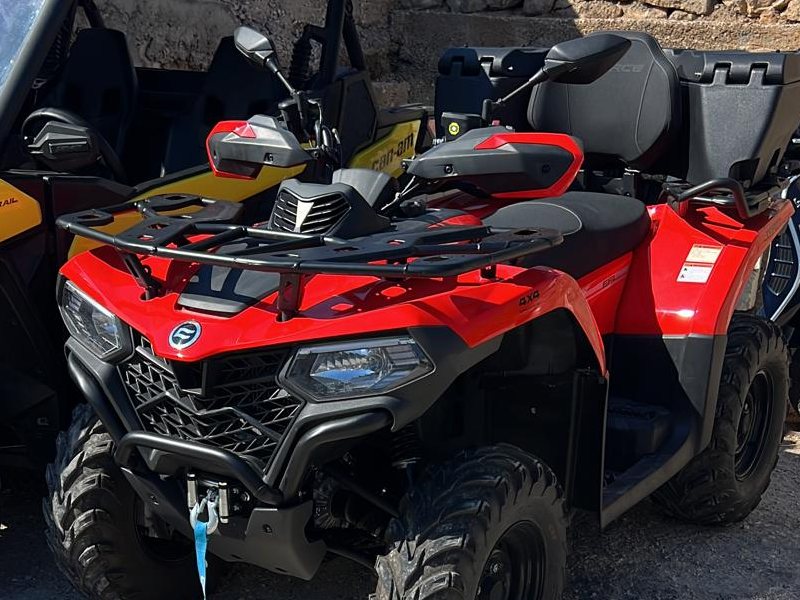 Red CFMoto 520cc quad parked beside the buggy